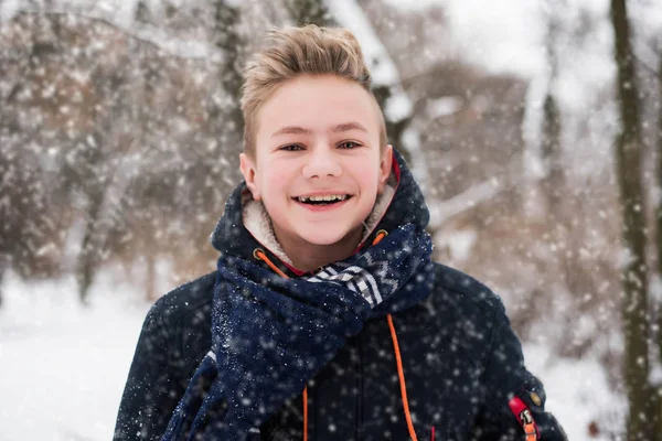 Christmas, New Year, winter holidays concept. Cute teenage boy in snow park. — Stock Photo, Image