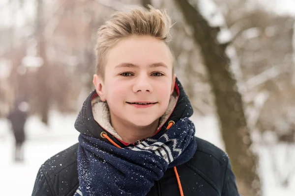 Christmas, New Year, winter holidays concept. Cute teenage boy in snow park. — Stock Photo, Image