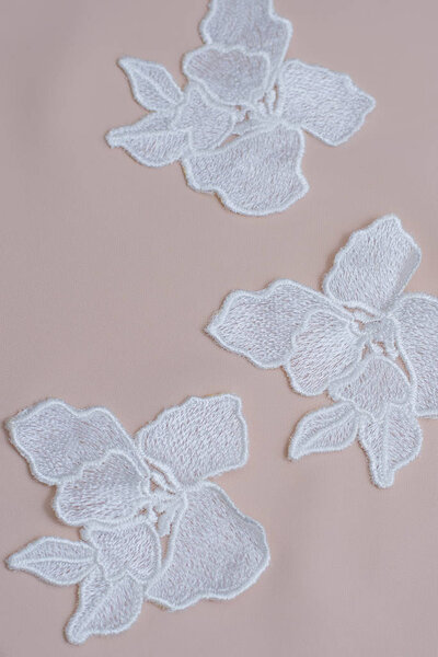 Texture lace fabric. lace on white background studio. thin fabric made of yarn or thread. a background image of ivory-colored lace flowers. White lace on beige background.