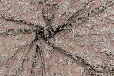 Doku danteli kumaş. Beyaz arka plan stüdyosunda dantel. İplik ya da iplikten yapılmış ince kumaş. Fildişi renkli dantel kumaşın arkaplan resmi. Bej arkaplanda gri dantel.