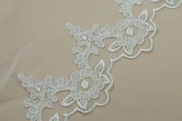 Texture lace fabric. lace on white background studio. thin fabric made of yarn or thread. a background image of ivory-colored lace cloth. White lace on beige background. — Stock Photo, Image