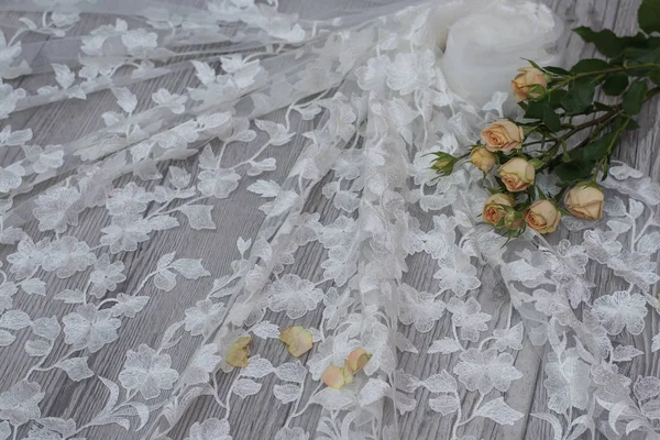 Белый деревянный фон с белыми весенними цветами роз и кружевной ленты. Счастливого женского дня. Текстура кружева на деревянном фоне. — стоковое фото
