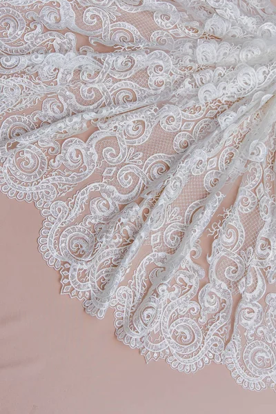 Texture lace fabric. lace on white background studio. thin fabric made of yarn or thread. a background image of ivory-colored lace cloth. White lace on beige background. Stock Image