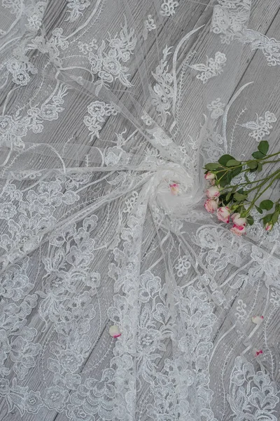 하얀 나무 배경에 흰 봄 꽃 장미와 레이스 리본 이 있다. 행복 한 여자들의 날. 나무 배경 위에 놓인 레이스의 구조. — 스톡 사진
