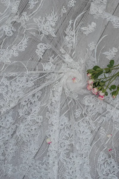 Fondo bianco in legno con fiori bianchi primaverili rose e nastro di pizzo. Felice giorno delle donne. La trama del pizzo su sfondo di legno. — Foto Stock