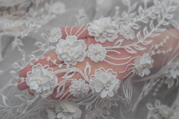 White wooden background with white spring flowers roses and lace ribbon. Happy womans day. The texture of lace on wooden background.