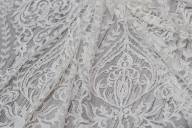 Beyaz ahşap arka plan, beyaz bahar çiçekleri güller ve dantel kurdeleler. Mutlu kadınlar günü. Tahta zemindeki dantelin dokusu.