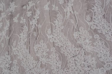 Beyaz ahşap arka plan, beyaz bahar çiçekleri güller ve dantel kurdeleler. Mutlu kadınlar günü. Tahta zemindeki dantelin dokusu.