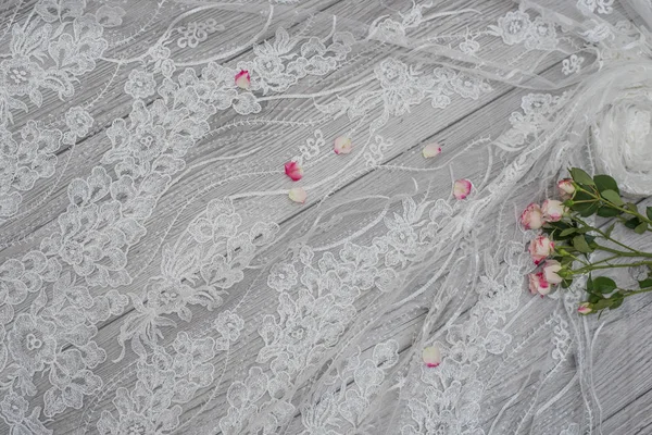 하얀 나무 배경에 흰 봄 꽃 장미와 레이스 리본 이 있다. 행복 한 여자들의 날. 나무 배경 위에 놓인 레이스의 구조. — 스톡 사진
