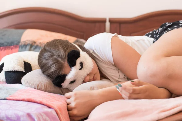 Linda adolescente en su cama en pijama y la máscara del sueño panda . —  Fotos de Stock