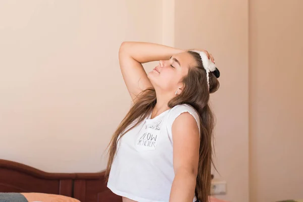 Cute teenage girl in her bed in pajamas and sleep mask panda. — Stok fotoğraf