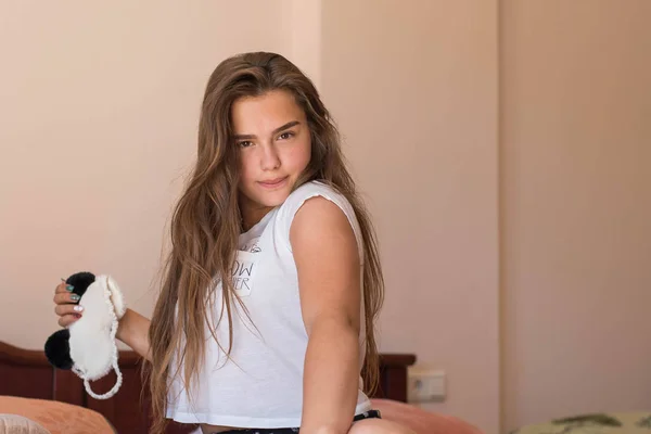 Linda adolescente en su cama en pijama y la máscara del sueño panda . —  Fotos de Stock