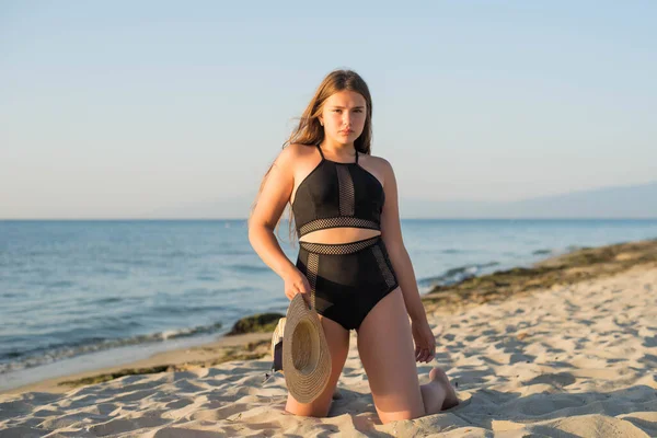 Allegro plus size adolescente indossa cappello godendo la spiaggia. sorridente, felice, emozione positiva, stile estivo. — Foto Stock