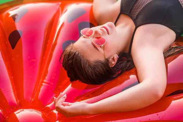 Happy teenage girl wearing red sunglasses floating with watermelon lilos, sea - having fun swimming in summer vacation - Youth lifestyle, travel and party concept — Stock Photo, Image