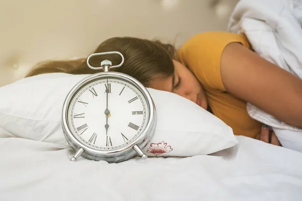 Linda adolescente en la cama tratando de despertar con despertador —  Fotos de Stock