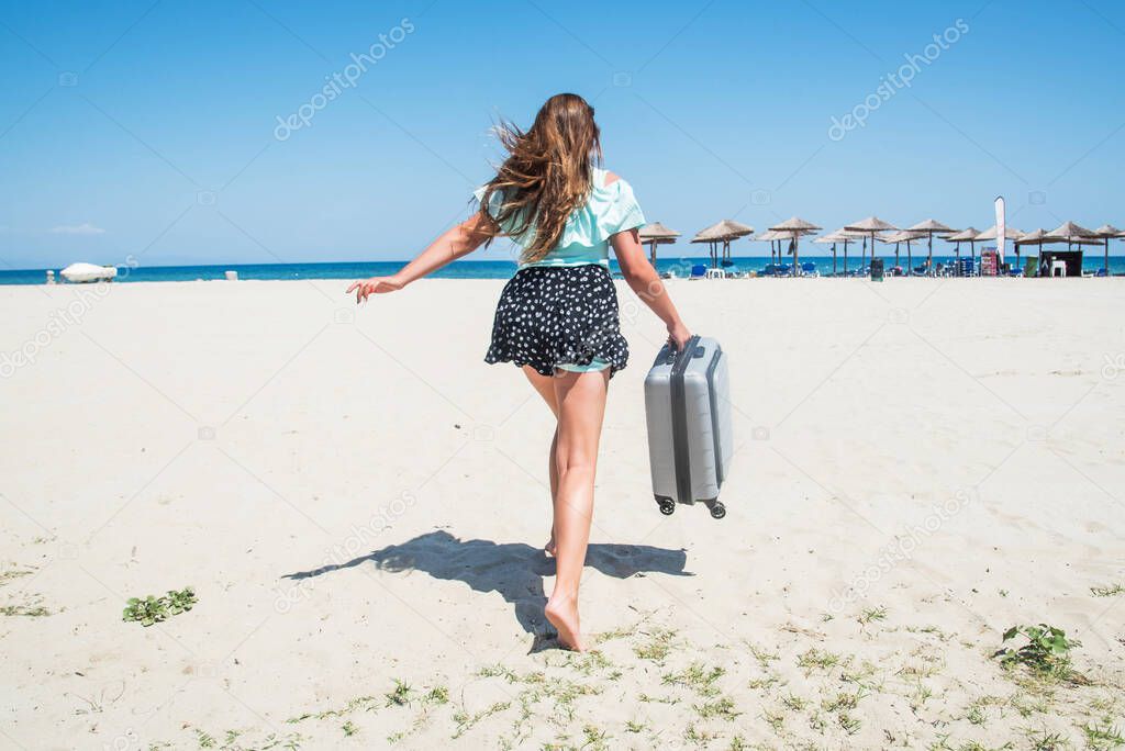 Beautiful girl with a bag in a beach. beautiful teenage girl running with suitcase, white sand, tropics luggage destination