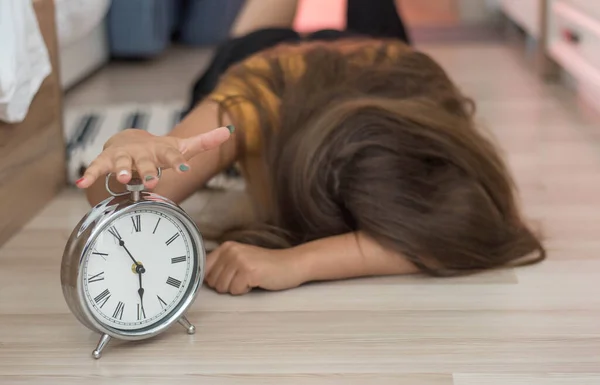 Jovencita soñolienta tratando de matar el despertador. Despertarse temprano, no dormir lo suficiente, conseguir el concepto de trabajo. Mujer estirando la mano a sonar alarma dispuesto a apagarlo —  Fotos de Stock