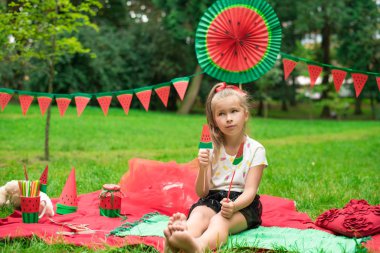 Karpuz partisi, parkta çocuklar için piknik. Karpuz günü. Sevimli küçük kız..