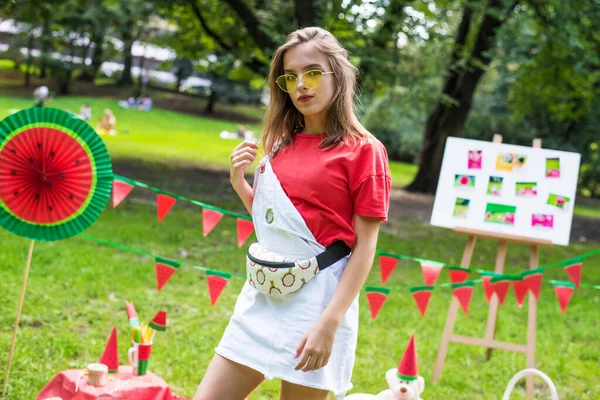 Nice teen girl having fun watermelon party In the park. Excellent sunny weather. Summer concept. Watermelon party, picnic, day. yellow sunglasses. — ストック写真