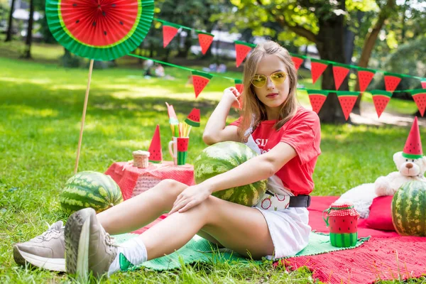 Nice teen girl having fun watermelon party In the park. Excellent sunny weather. Summer concept. Watermelon party, picnic, day. yellow sunglasses. — Stock Photo, Image