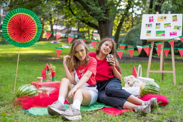 Two nice teen girls having fun eating watermelon In the park. Excellent sunny weather. Summer concept. Watermelon party, picnic, day — ストック写真