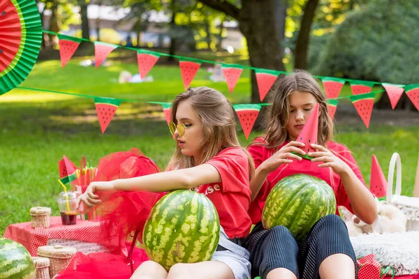 Deux jolies adolescentes qui s'amusent à manger de la pastèque dans le parc. Très beau temps ensoleillé. Concept d'été. fête de pastèque, pique-nique, jour — Photo