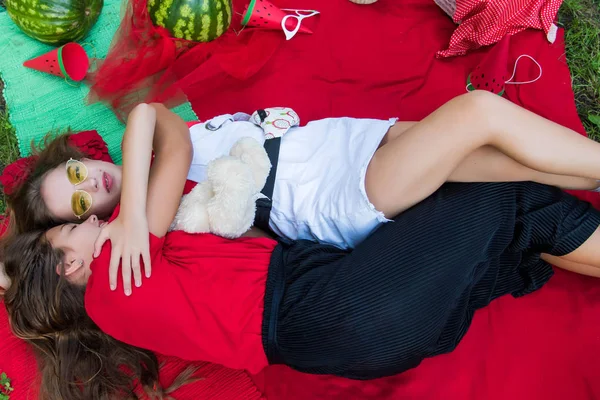 Zwei hübsche Teenie-Mädchen, die im Park Wassermelonen essen. Ausgezeichnetes sonniges Wetter. Sommerkonzept. Wassermelonenparty, Picknick, Tag — Stockfoto