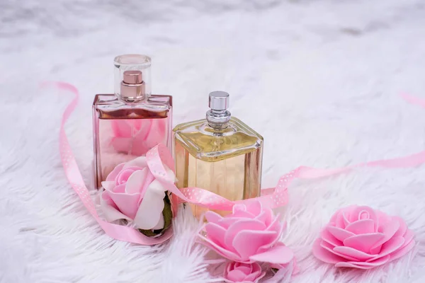 Beyaz kabarık arka planda çiçekli parfüm şişeleri — Stok fotoğraf