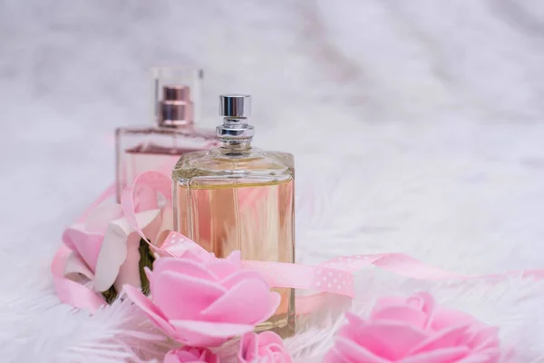 Botella de perfume con flores sobre fondo blanco esponjoso —  Fotos de Stock