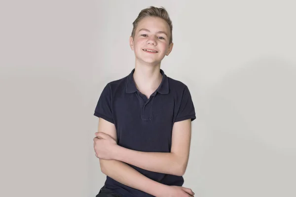 Portrait of a teenager boy smiling on gray background — Stock Photo, Image