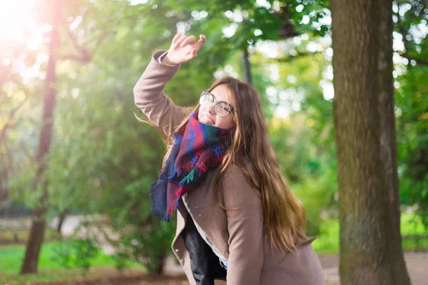 Portret z piękna dziewczyna w parku. Nastoletnie dziewczyny z kolorowy szalik i brązowy płaszcz. Zdjęcie z bliska. Młody student zabawy. Styl życia zdjęcie. pojęcie szczęścia - uśmiechnięte dziewczyny. — Zdjęcie stockowe