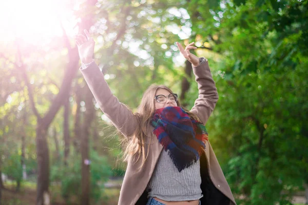 Portrait of a beautiful girl in park. Teenage girl with colorful scarf and brown coat. Close up photo. Young student have fun. Lifestyle photo. happiness concept - smiling girl. Stock Picture