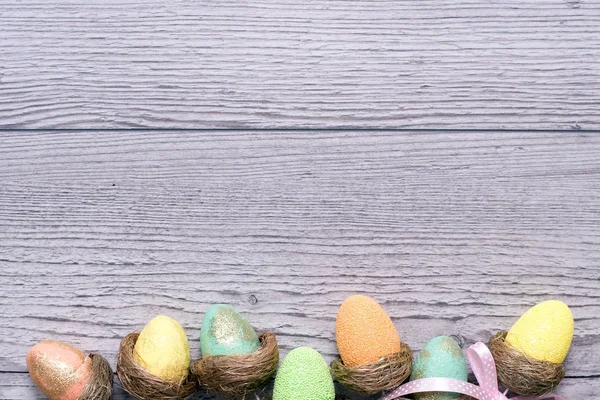 Composizione pasquale con uova colorate su sfondo ligneo, spazio per testo. Divertente decorazione. Buona Pasqua — Foto Stock