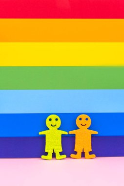 LGBT insan figürleri. İki erkek figürü alışılmadık oryantasyon gösteriyor. Evlilik ve aile, çift. Homoseksüel hakları. Gökkuşağı arkaplanı.