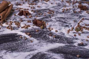 Hamur pişirmek için gereken malzemeler arasında un, şeker, tarçın, anason yıldızı, çırpma ve oklavanın koyu arkaplanda olması da var. Metin, üst görünüm ve tonlama için boş alan