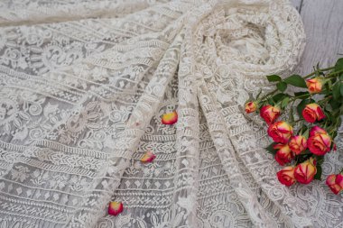 Beyaz ahşap arka plan, beyaz bahar çiçekleri güller ve dantel kurdeleler. Mutlu kadınlar günü. Tahta zemindeki dantelin dokusu.