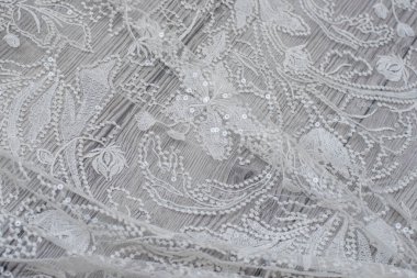 Beyaz ahşap arka plan, beyaz bahar çiçekleri güller ve dantel kurdeleler. Mutlu kadınlar günü. Tahta zemindeki dantelin dokusu.