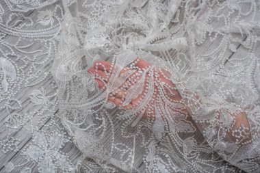 Beyaz ahşap arka plan, beyaz bahar çiçekleri güller ve dantel kurdeleler. Mutlu kadınlar günü. Tahta zemindeki dantelin dokusu.