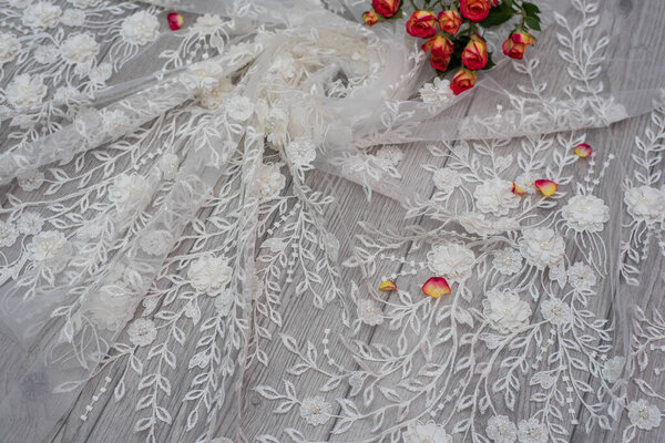 White wooden background with white spring flowers roses and lace ribbon. Happy womans day. The texture of lace on wooden background.