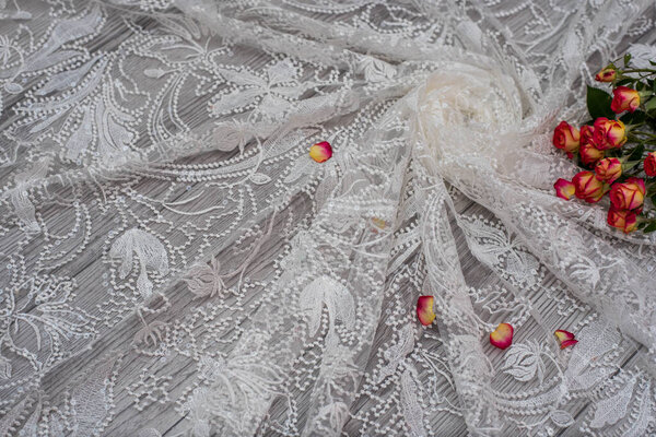 White wooden background with white spring flowers roses and lace ribbon. Happy womans day. The texture of lace on wooden background.