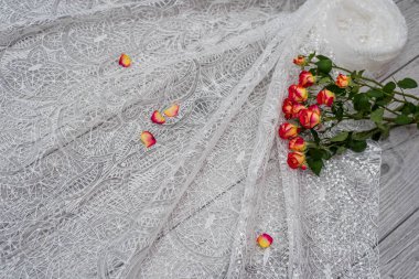 Beyaz ahşap arka plan, beyaz bahar çiçekleri güller ve dantel kurdeleler. Mutlu kadınlar günü. Tahta zemindeki dantelin dokusu.