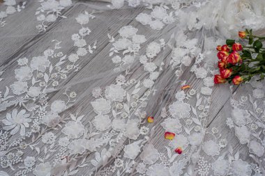 Beyaz ahşap arka plan, beyaz bahar çiçekleri güller ve dantel kurdeleler. Mutlu kadınlar günü. Tahta zemindeki dantelin dokusu.