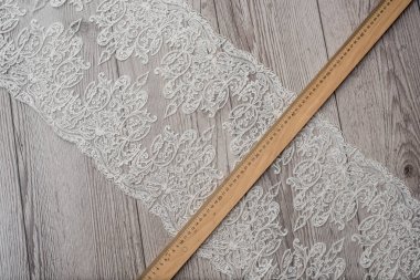 Beyaz ahşap arka plan, beyaz bahar çiçekleri güller ve dantel kurdeleler. Mutlu kadınlar günü. Tahta zemindeki dantelin dokusu.