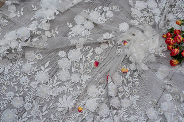 White wooden background with white spring flowers roses and lace ribbon. Happy womans day. The texture of lace on wooden background.