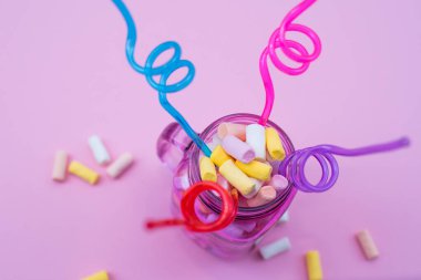 Borularla dolu bir bardakta beyaz şekerlemeler. Parti konsepti.