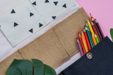 Ofis düzenleyicisi, beyaz, siyah, el işi renk ve pembe arka planda yaprak. Fotoğrafı kapat.