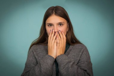 Dramatik bir portre. Endişe ve korku kavramı. Yüzü örten ellerden yoğun bir bakış..