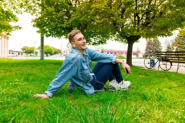 Jeune Homme Écoute Musique Sur Casque Gars Assis Sur Herbe — Photo