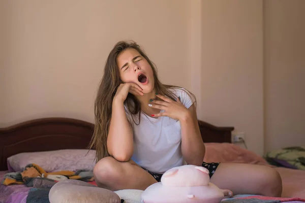Woman sleepy tired teenage girl yawning almost falling asleep. Health balance sleep deprivation concept. Female student at home.