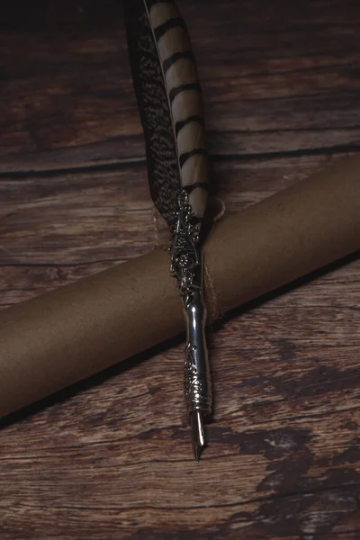 Koyu ahşap masadaki eski kağıt parşömenli eski tüy kalem. Mektup yazmak. Tarihsel atmosfer